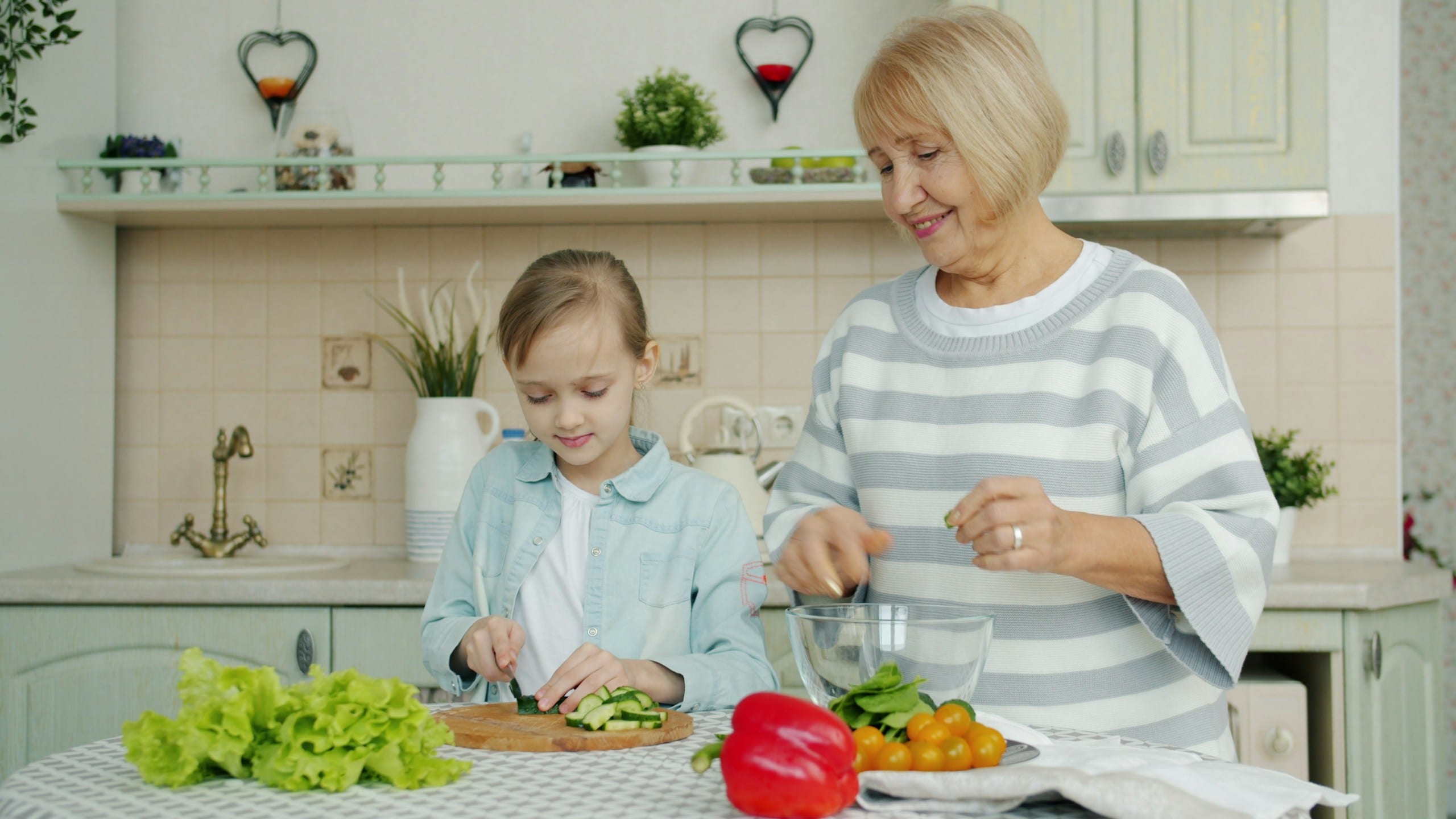 Angeh&ouml;rige und Pflegekraft unterst&uuml;tzen einen &auml;lteren Mann in der K&uuml;che